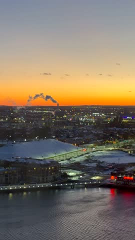 Panoramic view of the Baltimore city skyline and Inner Harbor at sunset with urban architecture and waterfront reflections. Vertical video.