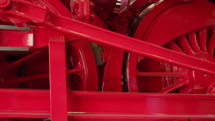 Close up shot of the wheels of a big steam locomotive, including side rods.