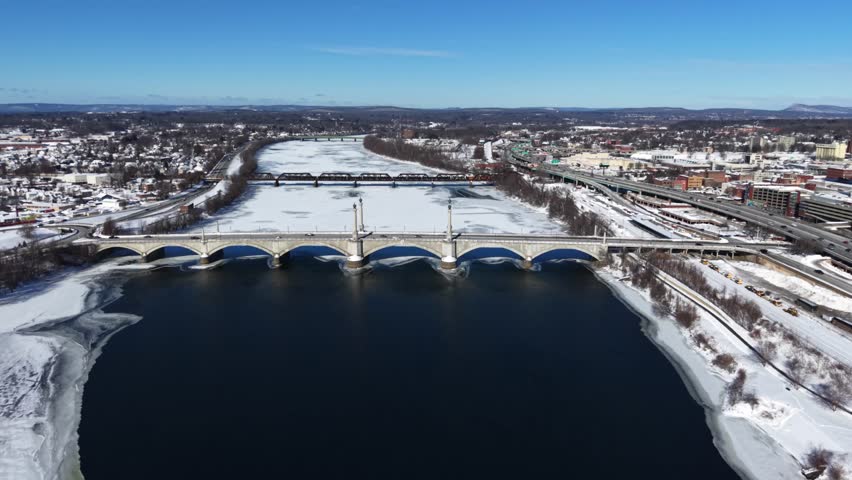 Memorial Bridge And Railroad Bridge Over Connecticut River In Winter In Springfield, Massachusetts, USA. - aerial shot