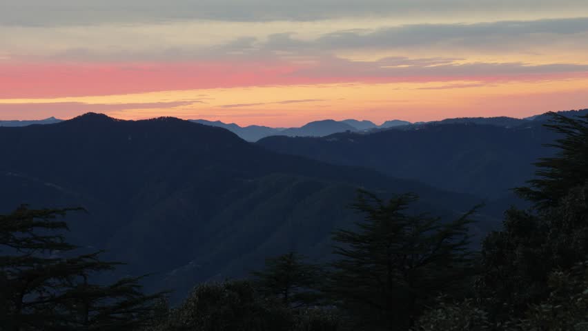 dramatic sunset over dark mountain ridges in peaceful landscape