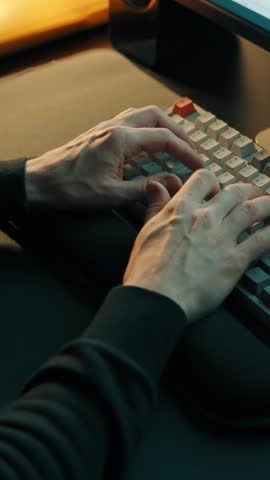 Man sitting at a computer and typing on a keyboard. Home office
