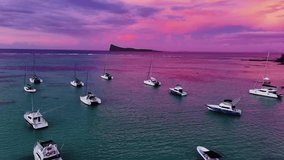 Anchored boats in a tropical lagoon captured during a vivid red sunset in Mauritius. Calm waters and a colorful sky create a serene island atmosphere, an aerial shot. - Powered by Shutterstock - Get 15% off with code: PIKWIZARD15