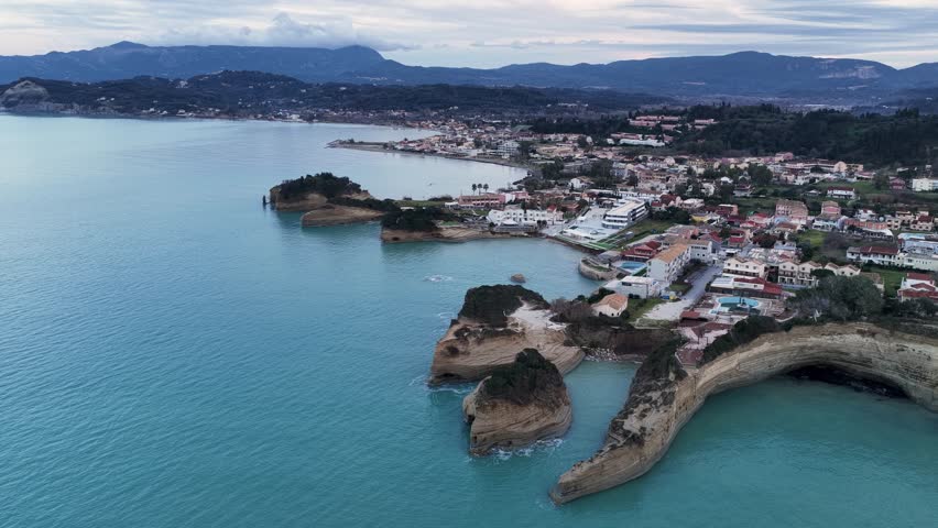 Aerial View of Famous Canal d'Amour in Sidari Corfu Greece with Unique Sandstone Rock Formations Turquoise Sea and Coastal Village Resort Landscape during Cloudy Sunset for Travel and Tourism Concepts