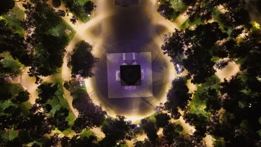Aerial night panorama of an urban park and purple monument lighting