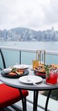 Mexican appetizers, quesadillas, nachos, and cocktails on rooftop table. Scenic city skyline and harbor background. Luxury outdoor dining experience Vertical. - Powered by Shutterstock - Get 15% off with code: PIKWIZARD15