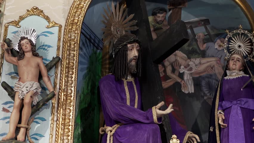 Church altar showing Jesus Christ carrying cross with saint statues