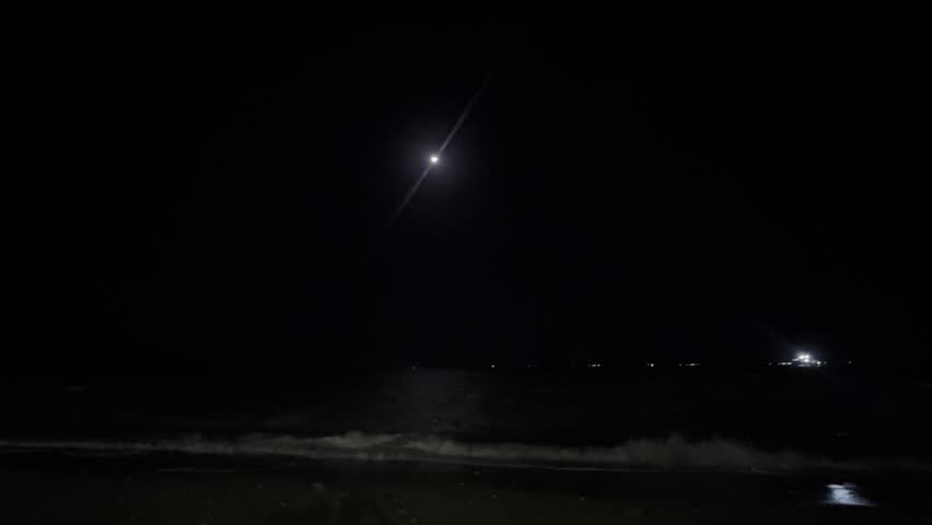 Moonlight over dark sea waves at night
Night seascape with bright moon in the sky, gentle waves on a dark beach and distant lights on the horizon, calm ocean under moonlight.