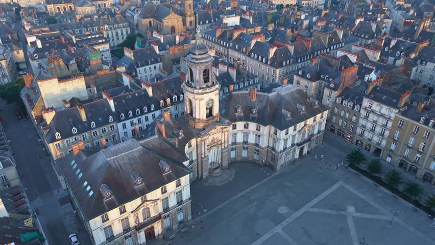 Place de la Mairie, the city hall, and the opera house at sunrise in the historic center of Rennes, France. Aerial drone orbiting