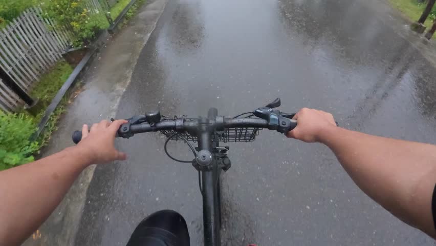 Riding Bicycle on Wet Road in Rain