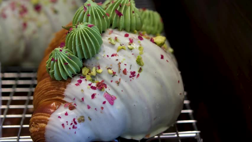 croissant with green filling Golden flaky pistachio croissant filled with smooth pistachio cream and sprinkled with crushed nuts on top, served fresh from the bakery oven