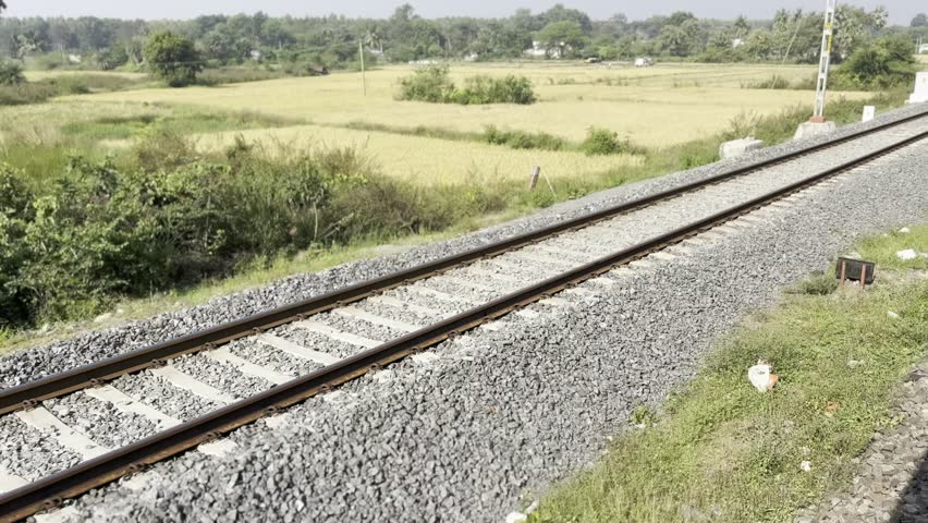 Railway tracks at sunset Steel rails and wooden sleepers on gravel ballast. Perspective lines leading forward. Transportation infrastructure detail. Travel and journey concept 