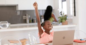African American mother and daughter child smiling raising arm typing on laptop at table for class. Family, education, home, learning, computer, focus, kitchen - Powered by Shutterstock - Get 15% off with code: PIKWIZARD15