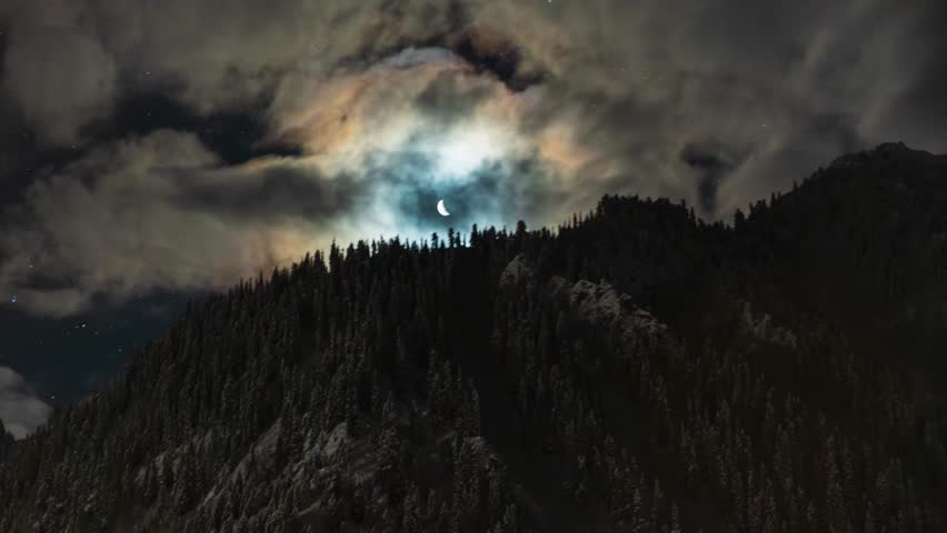 Cinematic 4K Night Timelapse of Crescent Moon Rising Over Silhouette Mountain Ridge with Fast Moving Storm Clouds