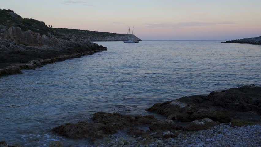 Boat on a beach bay at Cape Tainaron Matapan at sunset, in Greece