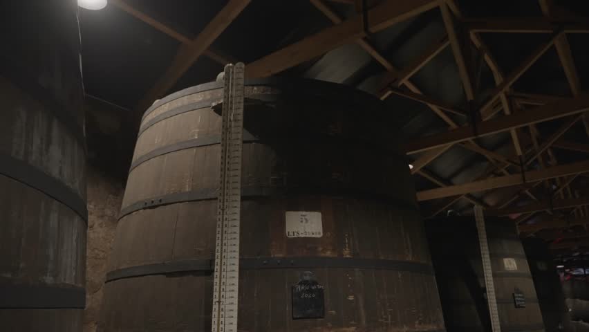 Large wooden wine barrels stored indoors in cellar