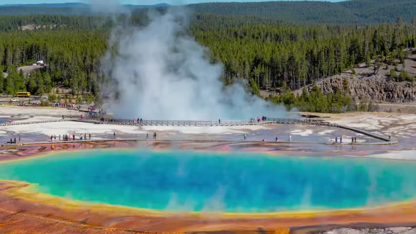 Grand Prismatic Spring in Yellowstone National Park with vibrant colors, steam rising, and boardwalk for visitors, showcasing natural beauty.
