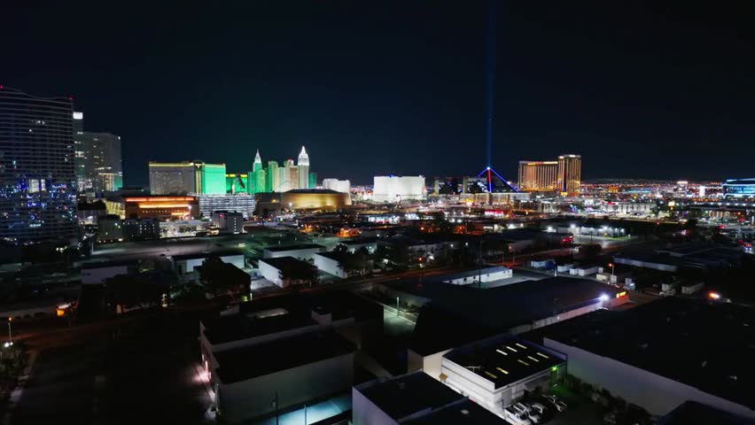 Las Vegas Strip skyline at night with glowing hotels, neon lights, and Luxor Pyramid beam shining across the sky, vibrant city nightlife.