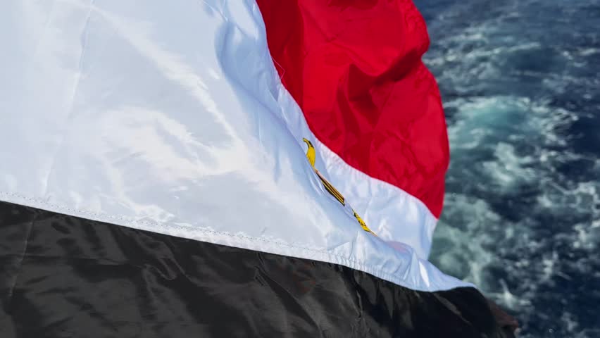 Extreme close-up of Egyptian national flag waving in the strong wind on floating boat in the Red Sea