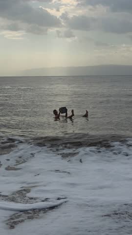 Vertical View Of A Man Floating While Reading Over The Dead Sea In Jordan. Static Shot