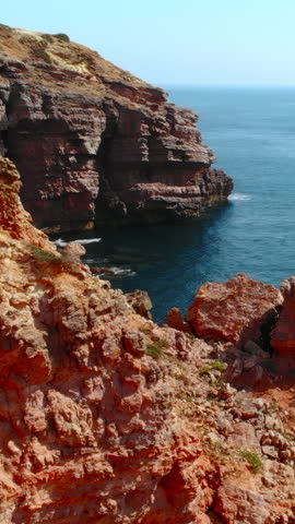 majestic red cliffs over serene waters, dramatic seaside landscape with rugged cliffs and tranquil pools