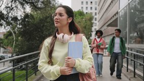 Hispanic student woman going to classes with group of college friends walking towards University building - Powered by Shutterstock - Get 15% off with code: PIKWIZARD15