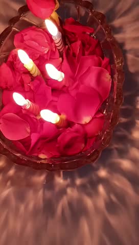 Romantic Dinner Setup – Rose Petals and Candles in Bowl
Description: A beautifully arranged romantic dinner table featuring a bowl filled with fresh rose petals and glowing candles as the centerpiece