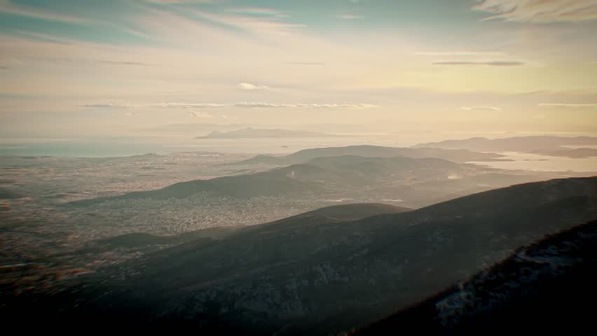 From 1,200 meters aboveMount Parnitha, the drone glides steadily toward Athens under a hazy sky. The footage captures the sprawling city nestled between encircling mount