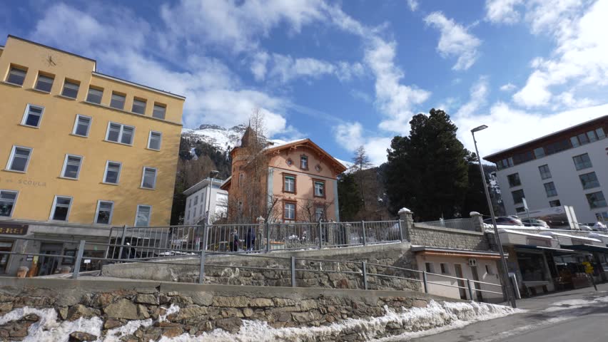 Picturesque street view with traditional buildings and snowy mountains in the swiss alps village