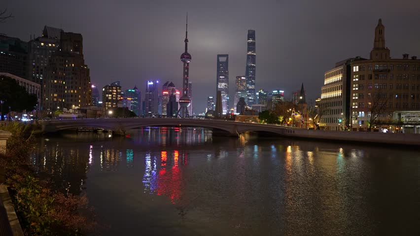 Shanghai, China: Footage of a the Shanghai city skyline reflection on the Suzhou creek river with ancient buildings and the skyscrapers of Pudong financial district in China at night