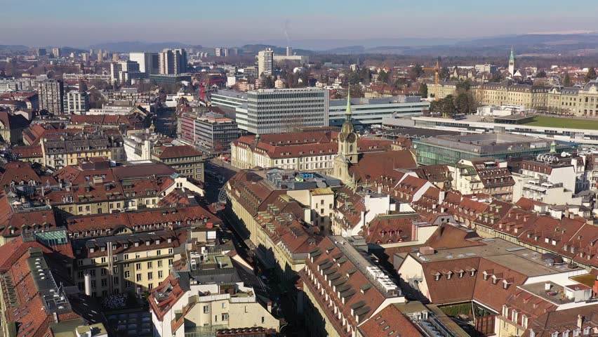 Bern, Switzerland: Aerial drone footage of Bern old town and city center toward the train station and Bern university building in Switzerland capital city. Shot with a tilt down motion