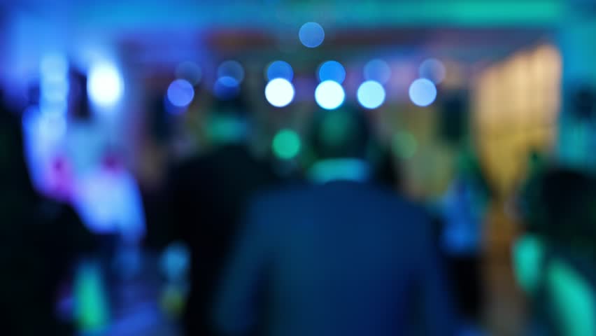 People dancing and celebrating at a lively event in a colorful venue