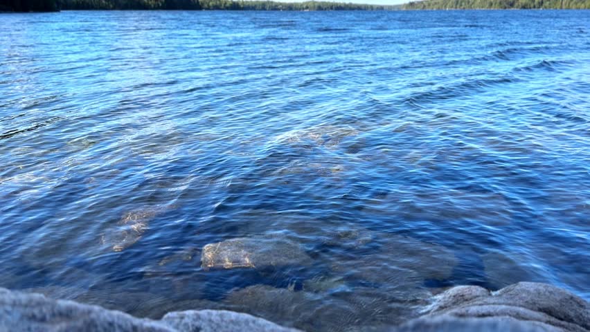 Clear blue water of Long Pond in Acadia National Park with rocks view
