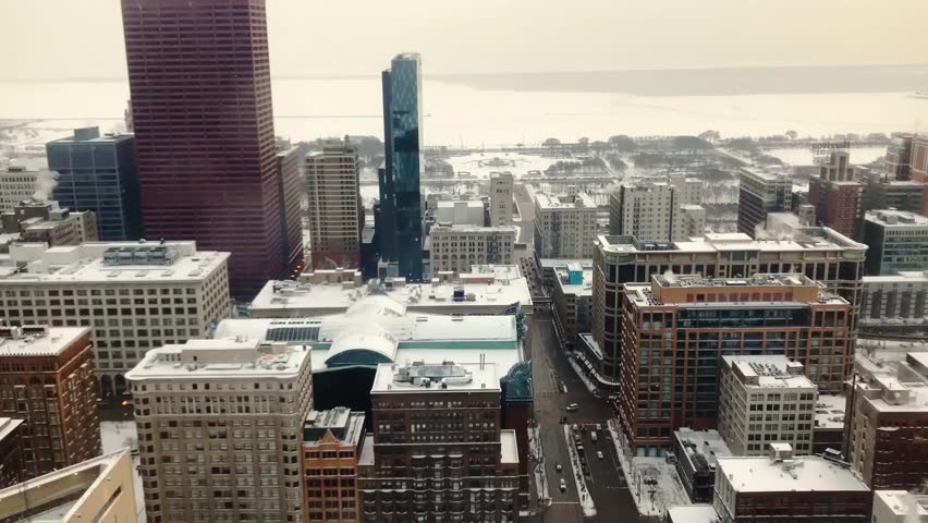 Time-lapse aerial view of snowy Chicago downtown with high-rise buildings and hazy winter atmosphere.