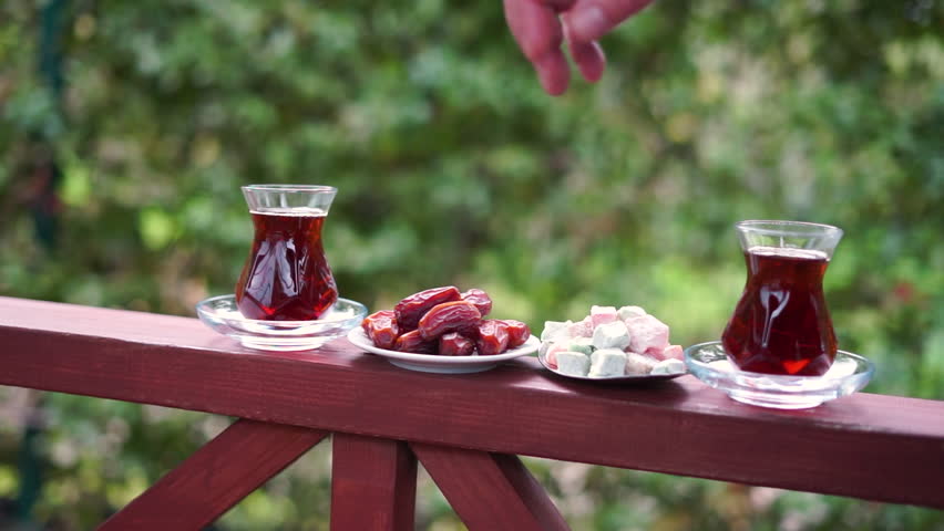 Dry Dates in a bowl and tea in armudu glass. Ramadan kareem.  Outdoor  background.