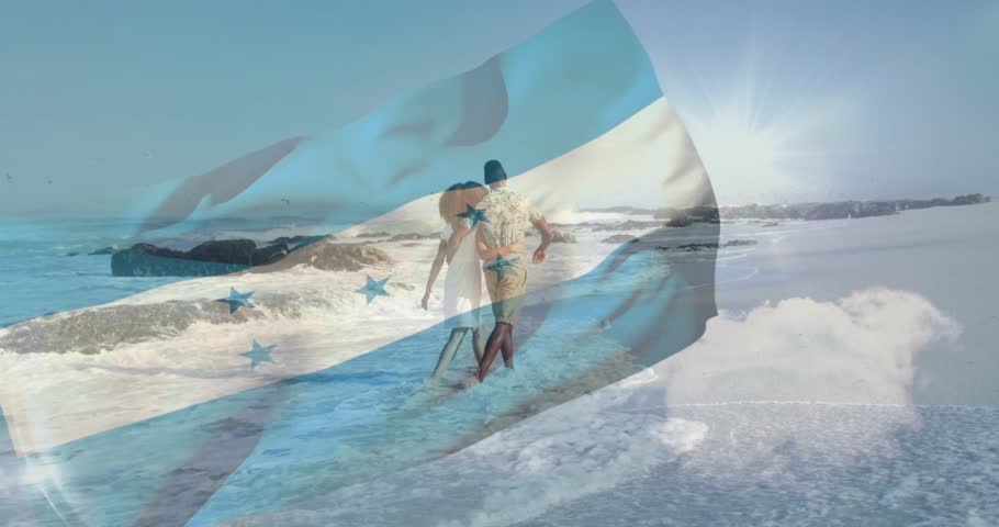 Man guiding woman starting walk toward sun, flag overlay drifting across couple and surf for travel. Beach, shore, horizon, silhouette, barefoot, backlit, waves