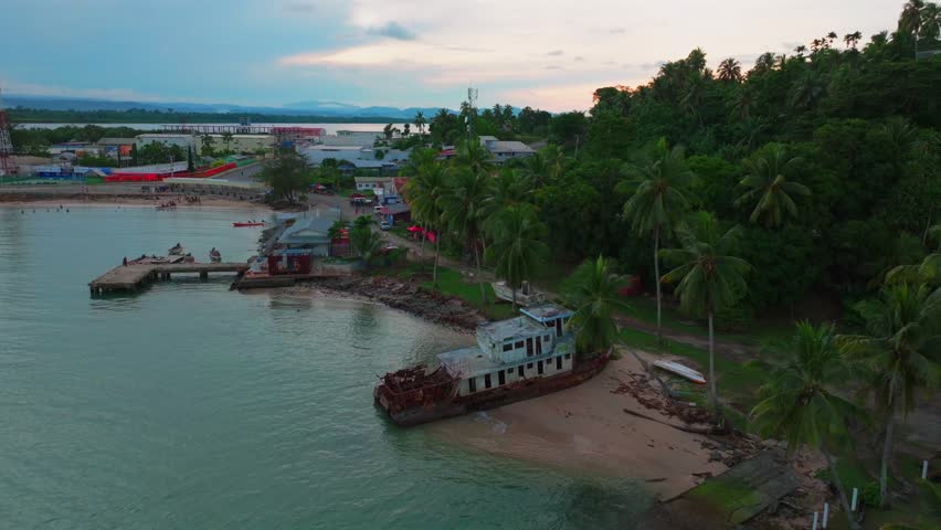 Wewak Hill Bay beached rusted fishing boat Boram Road Sea Wall Meni Boram Beach Wewak Papua New Guinea PNG Papua Niugini pier harbor view landscape Sepik Province coastline boats cars circle left