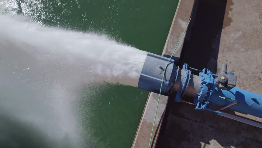 Howell Bunger valve in operation. Aerial view. Pressurized water outlet from dam wall. Water flowing from pumping in reservoir. Hydropower station pumping water. Water outlet from dam wall.