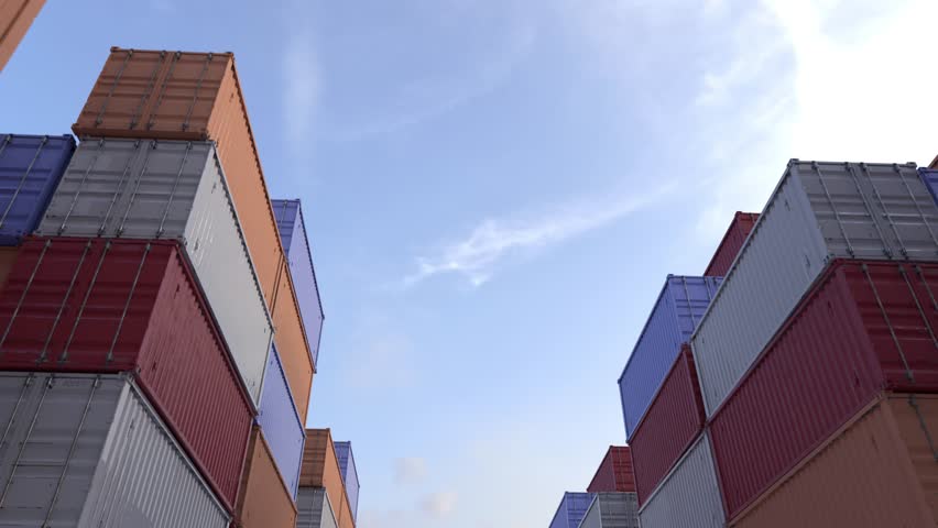 cargo airplane flying over stacked shipping containers