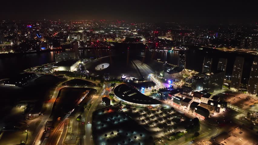 Aerial drone cinematic night video of iconic illuminated concert Hall of O2 Arena in North Greenwich Peninsula, London, United Kingdom