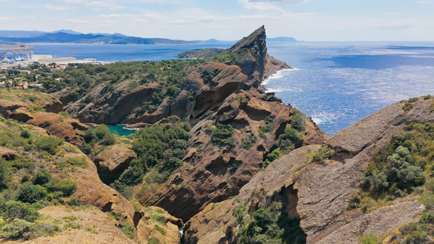 Aerial view of rugged sea cliffs along the Mediterranean coastline with deep blue water and rocky shoreline. Figuerolles Calanque, La Ciotat, France