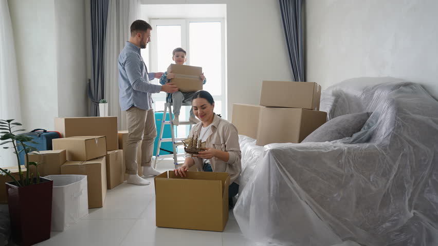 Happy family unpacking boxes together in new home