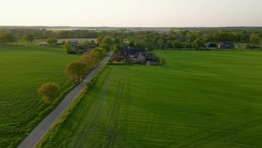 Aerial view of cyclists riding on a rural road at sunset