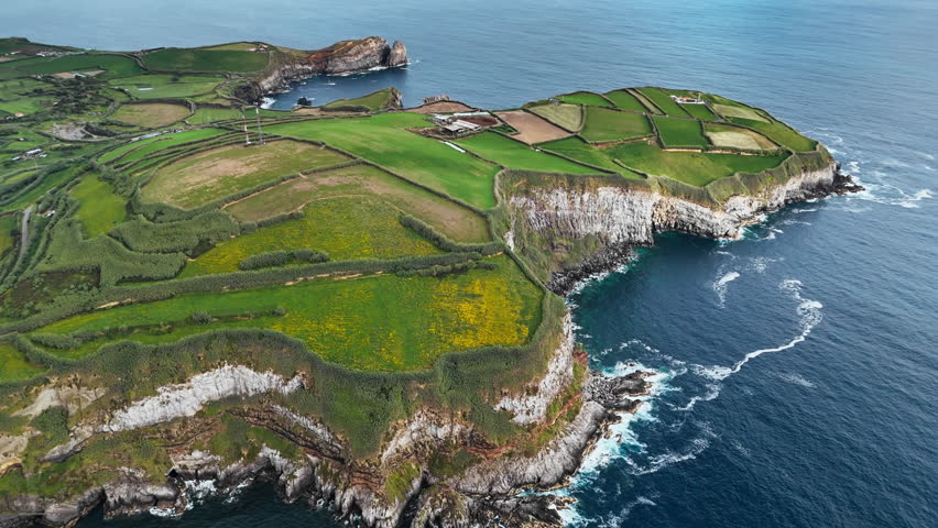 Agricultural patchwork landscape along rocky Atlantic shore in Azores, Portugal. Aerial view