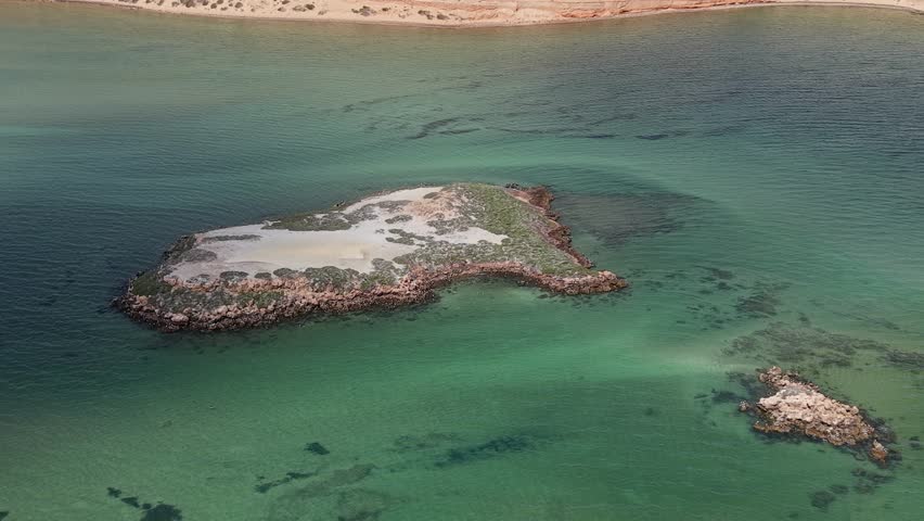 Aerial shot of a winding Eagle Bluff Lookout boardwalk to a sandy cliff lookout overlooking clear turquoise Waters of Henri Freycinet Harbour and an expansive arid coastline under a blue sky, Denham, Francois Peron NP, Shark Bay, Western Australia.