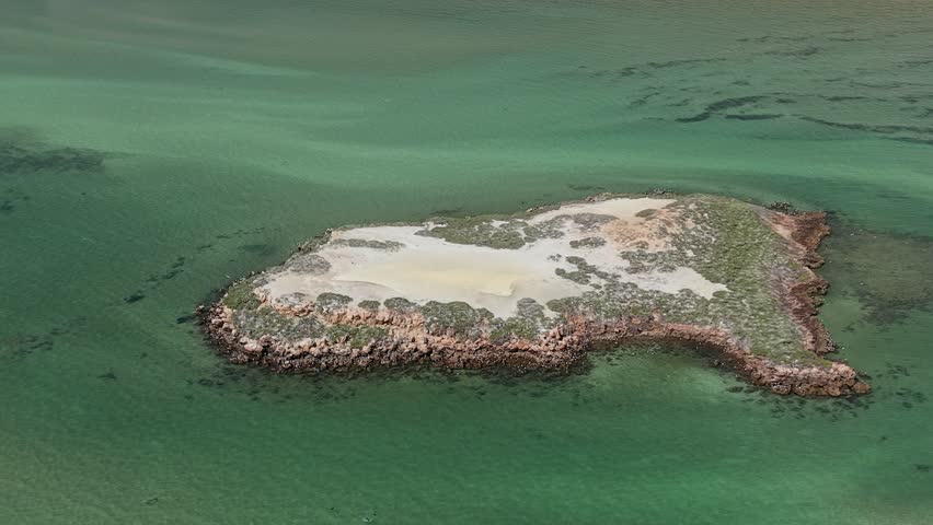 Aerial shot of a winding Eagle Bluff Lookout boardwalk to a sandy cliff lookout overlooking clear turquoise Waters of Henri Freycinet Harbour and an expansive arid coastline under a blue sky, Denham, Francois Peron NP, Shark Bay, Western Australia.
