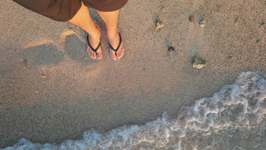 Feet in Flip-Flops at the Ocean Shore