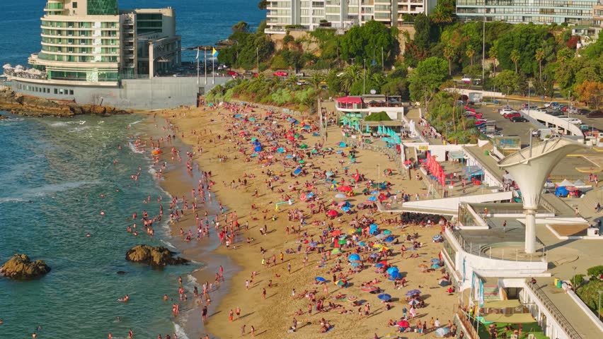 Telephoto aerial view of Caleta Beach completely full on a sunny day in Viña del Mar, Chile