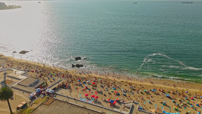Aerial view of Caleta Abarca beach completely full on a sunny day, Viña del Mar, Chile