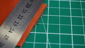 In a tanner's workshop, leather is measured and cut with a metal ruler. The process shows careful work and attention to detail. The workspace is well-lit and organized for the task. - Powered by Shutterstock - Get 15% off with code: PIKWIZARD15