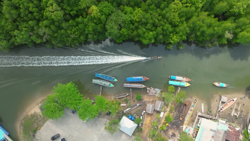 Aerial view of boats navigating a tranquil river in Thailands lush landscape